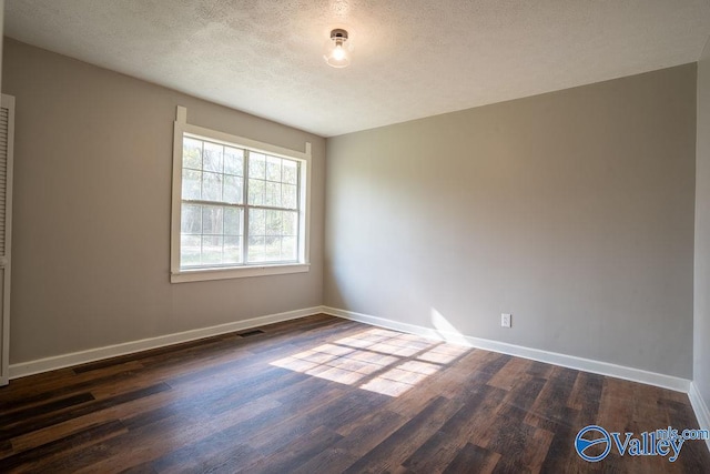 unfurnished room featuring dark hardwood / wood-style floors and a textured ceiling