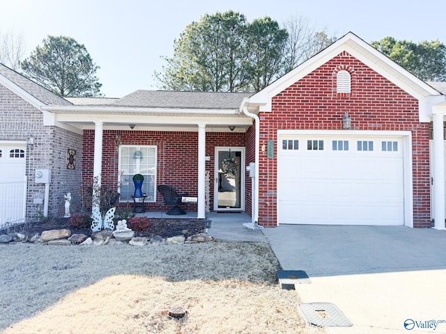 ranch-style home featuring a garage, covered porch, concrete driveway, and brick siding