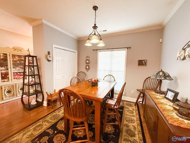 dining space with dark wood-style floors, visible vents, crown molding, and baseboards