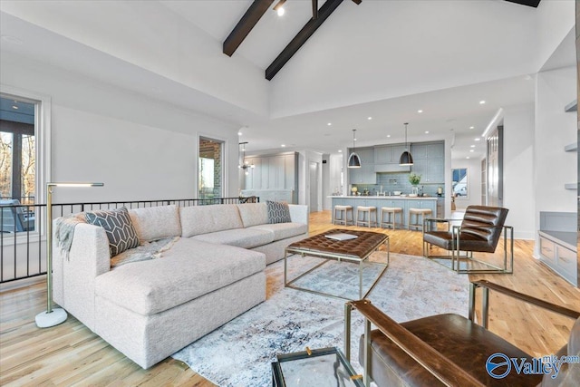 living room with baseboards, light wood-type flooring, high vaulted ceiling, beam ceiling, and recessed lighting