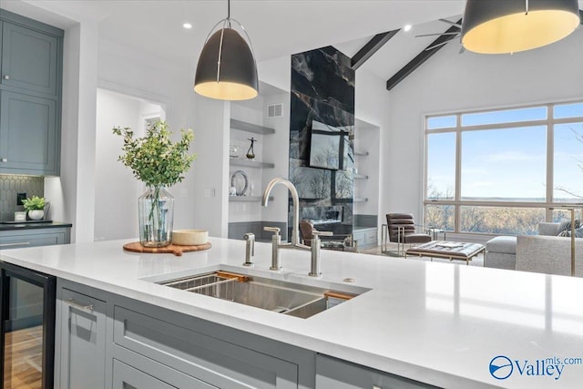 kitchen with beverage cooler, visible vents, open floor plan, light countertops, and a sink