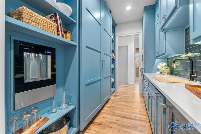 interior space featuring light wood-type flooring, a sink, and recessed lighting