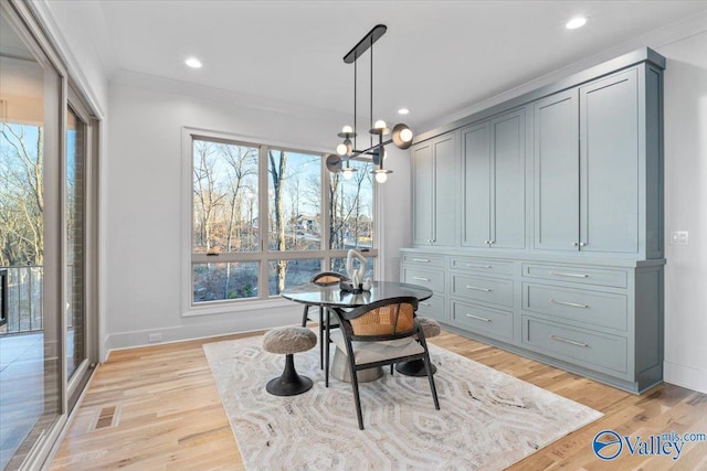 dining room featuring visible vents, light wood-style floors, ornamental molding, a chandelier, and baseboards