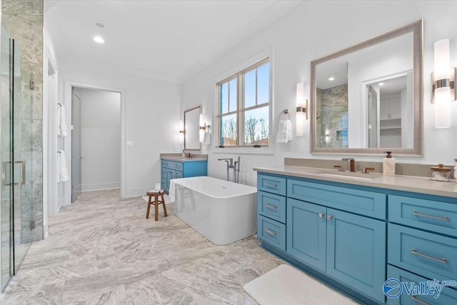 full bath featuring a freestanding tub, two vanities, a sink, and a shower stall