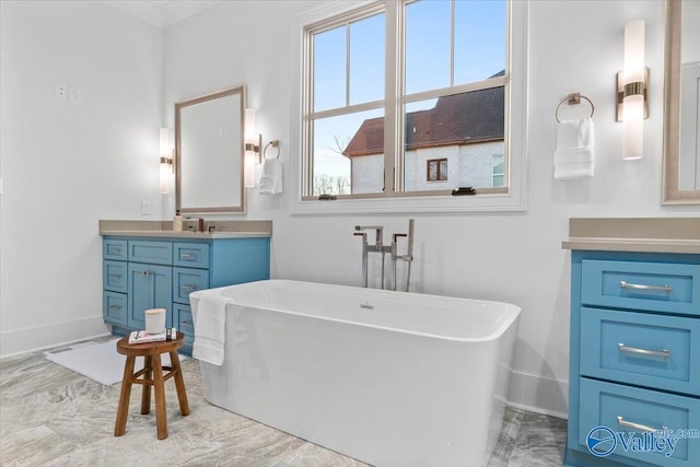 bathroom with a soaking tub, vanity, and baseboards