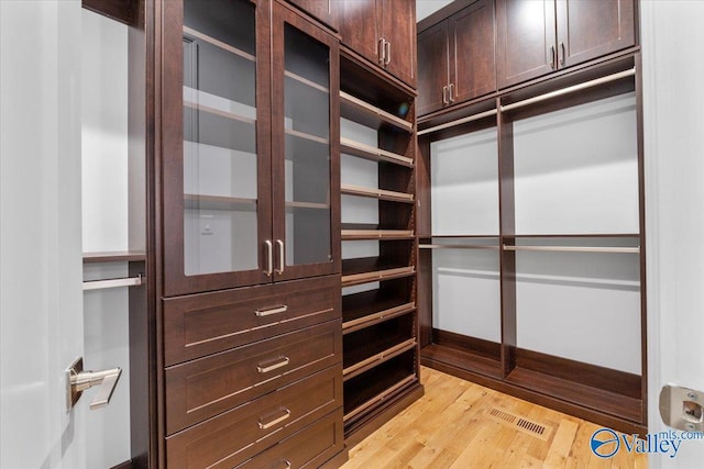 walk in closet with light wood-type flooring and visible vents