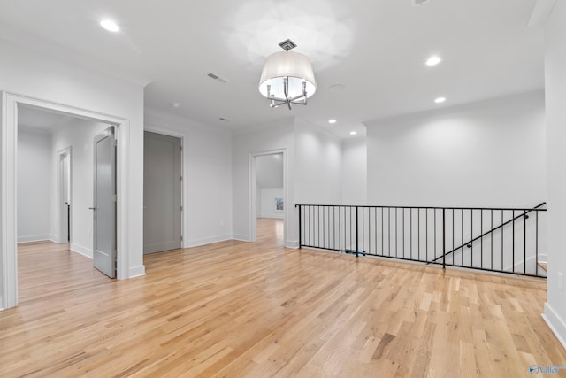 unfurnished room with ornamental molding, light wood-type flooring, visible vents, and recessed lighting