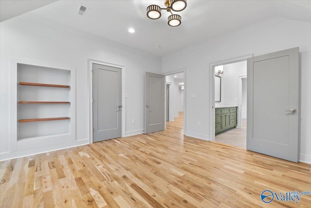 unfurnished bedroom with light wood-style floors, crown molding, ensuite bath, and baseboards