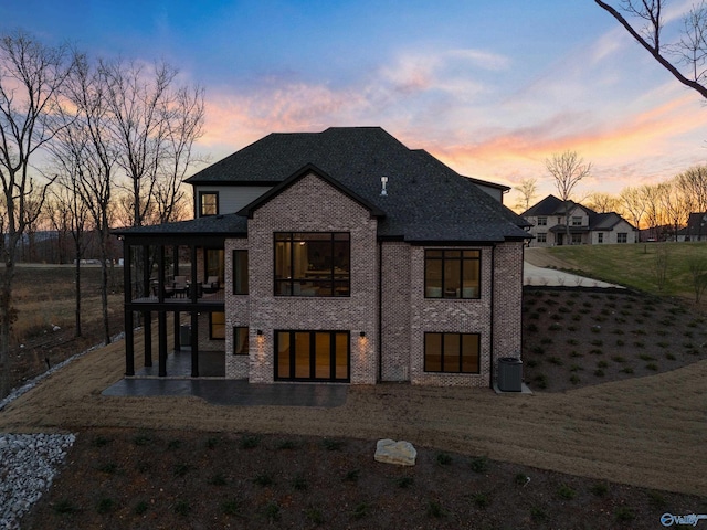 back of property featuring roof with shingles and brick siding