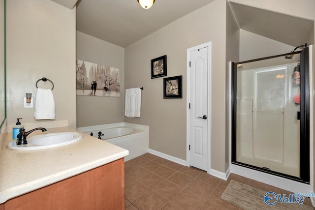 full bathroom featuring a stall shower, baseboards, a garden tub, tile patterned flooring, and vanity