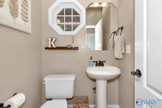 half bath featuring toilet and a sink