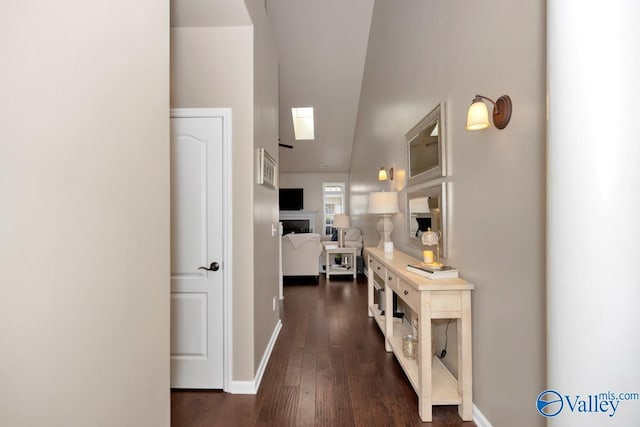 hall featuring dark wood-style floors and baseboards