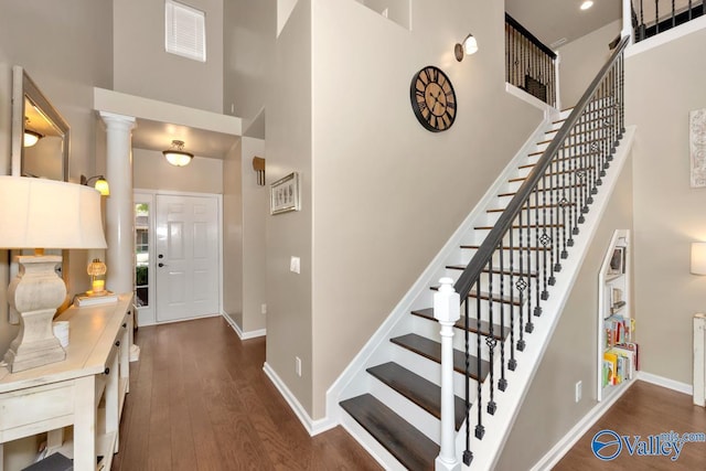 foyer with a high ceiling, baseboards, and wood finished floors