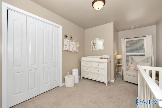 bedroom featuring baseboards, visible vents, a closet, and light colored carpet