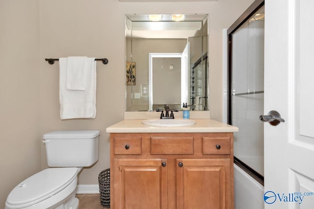 full bath featuring baseboards, combined bath / shower with glass door, vanity, and toilet