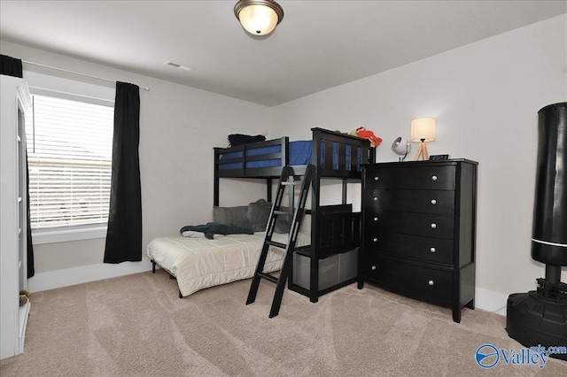 carpeted bedroom featuring baseboards and visible vents