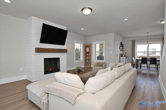 living room with recessed lighting, baseboards, wood finished floors, and a fireplace