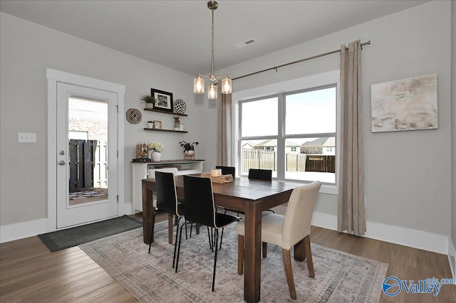 dining room with visible vents, plenty of natural light, and wood finished floors