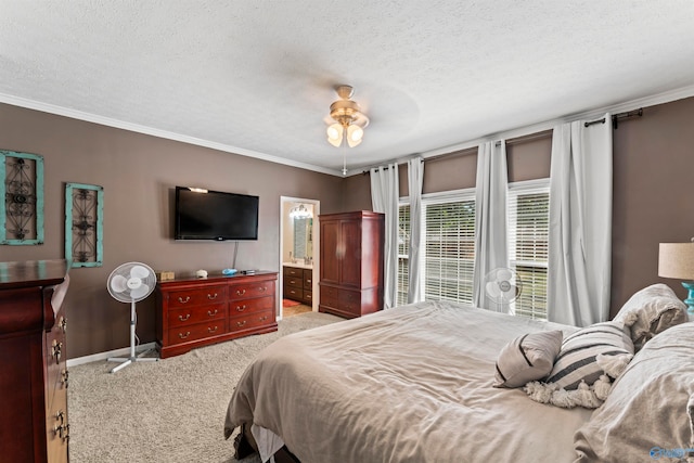 carpeted bedroom with crown molding, a textured ceiling, ensuite bath, and ceiling fan