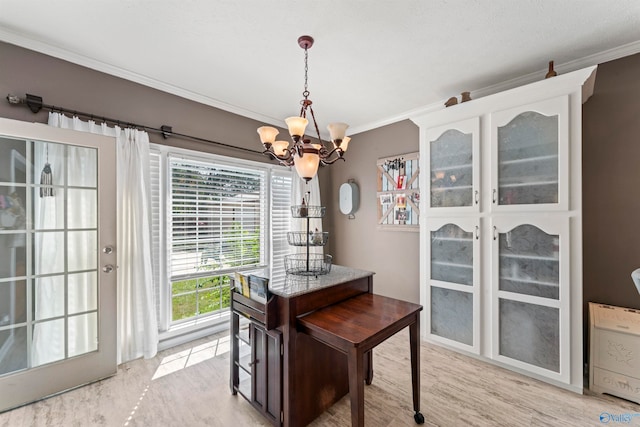 dining area with light hardwood / wood-style floors, a notable chandelier, and ornamental molding