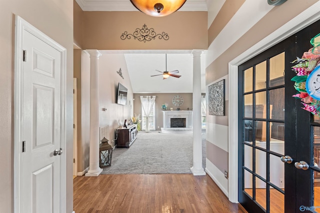 hallway featuring hardwood / wood-style flooring, vaulted ceiling, decorative columns, crown molding, and french doors