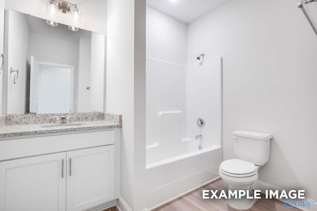 full bath with toilet, vanity, shower / tub combination, wood finished floors, and baseboards