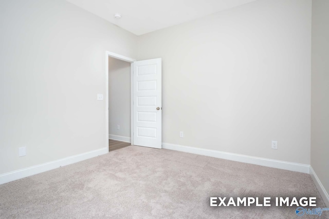 unfurnished room featuring carpet and baseboards