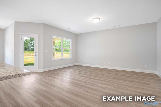 unfurnished living room featuring baseboards and light wood-style floors