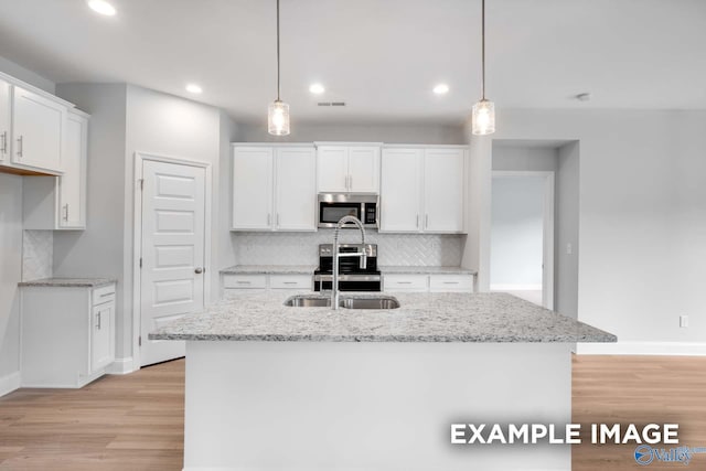 kitchen with light wood finished floors, white cabinetry, visible vents, and stainless steel appliances