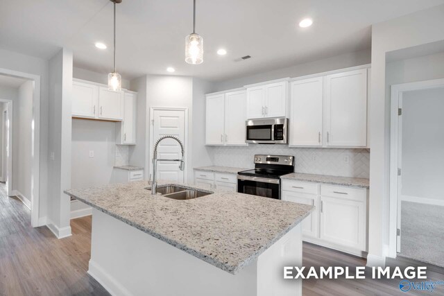 kitchen with appliances with stainless steel finishes, white cabinets, visible vents, and a sink