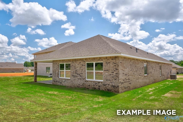 view of side of home with brick siding, roof with shingles, a lawn, crawl space, and a patio area