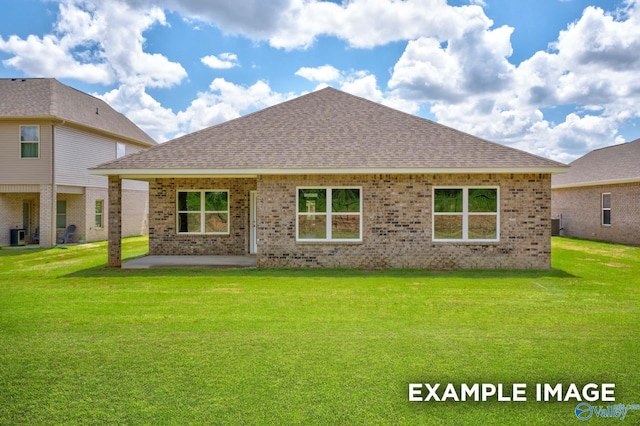 rear view of property featuring a shingled roof, brick siding, and a lawn