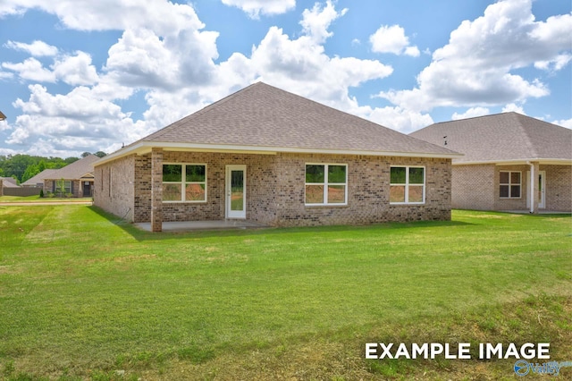 rear view of property with brick siding, roof with shingles, a patio area, and a yard