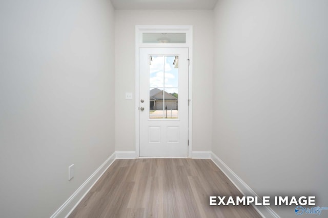 doorway to outside with baseboards and wood finished floors