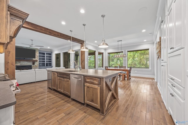 14 Blue Meadow Way, Gurley, AL 35748 - kitchen featuring dishwasher, a sink, ceiling fan, light wood-style flooring, and a stone fireplace