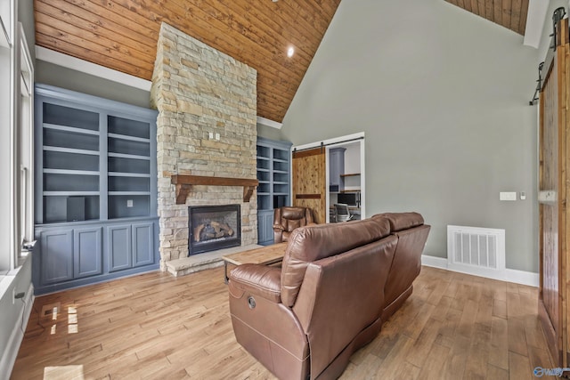 14 Blue Meadow Way, Gurley, AL 35748 - living area featuring a barn door, wood ceiling, high vaulted ceiling, a stone fireplace, and hardwood / wood-style flooring