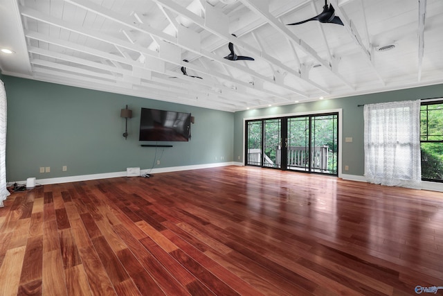 unfurnished living room featuring hardwood / wood-style flooring and beam ceiling