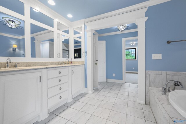 bathroom featuring ornamental molding, vanity, a relaxing tiled tub, and tile patterned flooring