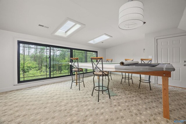 game room with light colored carpet and vaulted ceiling with skylight