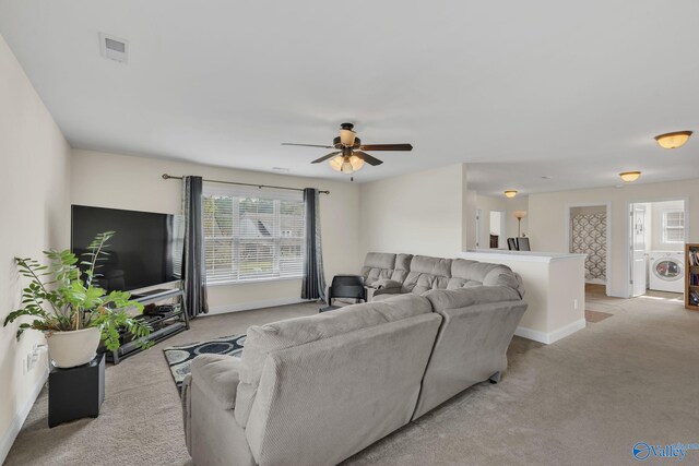 carpeted living room featuring ceiling fan and washer / clothes dryer