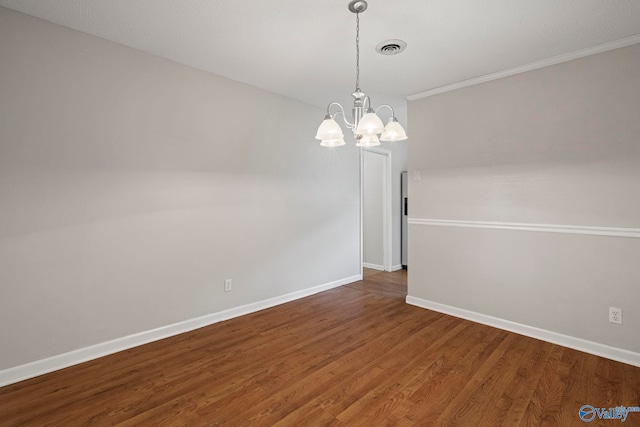 702 Royce Cir SE, Huntsville, AL 35803 - empty room featuring a chandelier, wood finished floors, and ornamental molding