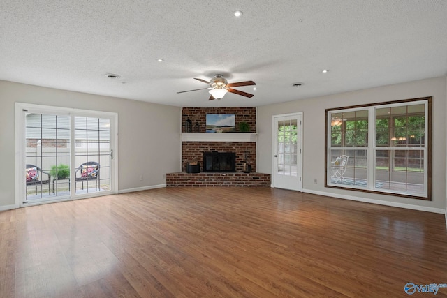 702 Royce Cir SE, Huntsville, AL 35803 - unfurnished living room with a textured ceiling, ceiling fan, wood finished floors, a brick fireplace, and recessed lighting