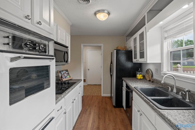 702 Royce Cir SE, Huntsville, AL 35803 - kitchen with appliances with stainless steel finishes, white cabinets, glass insert cabinets, dark wood-type flooring, and a textured ceiling