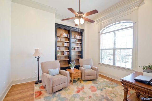 living area with a wealth of natural light, light wood-type flooring, and crown molding