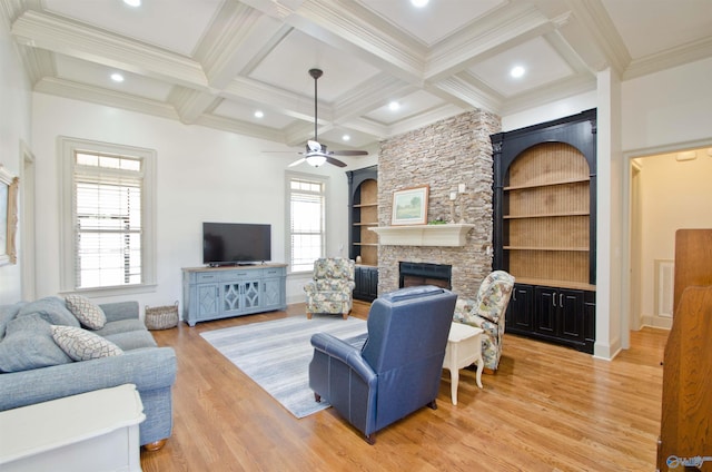 living room featuring coffered ceiling, light wood finished floors, beam ceiling, a fireplace, and ornamental molding