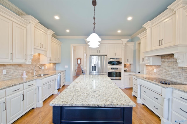 kitchen featuring a center island, stainless steel appliances, light wood-style floors, and a sink