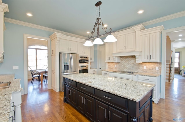 kitchen featuring stainless steel appliances, tasteful backsplash, light wood-style floors, and white cabinets