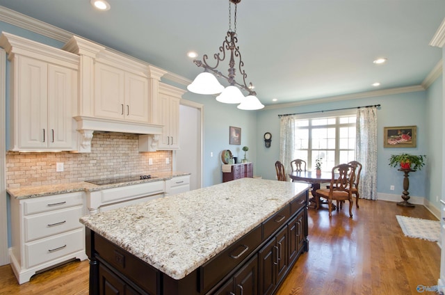 kitchen with light wood finished floors, dark brown cabinets, ornamental molding, decorative backsplash, and black electric cooktop