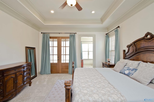 bedroom featuring light carpet, french doors, a raised ceiling, and ornamental molding