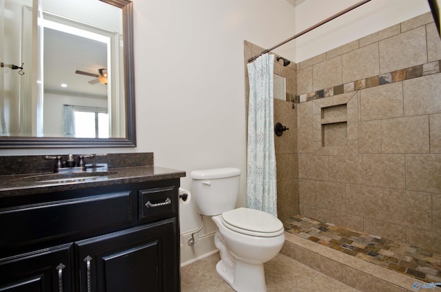 bathroom featuring vanity, a tile shower, ceiling fan, tile patterned floors, and toilet